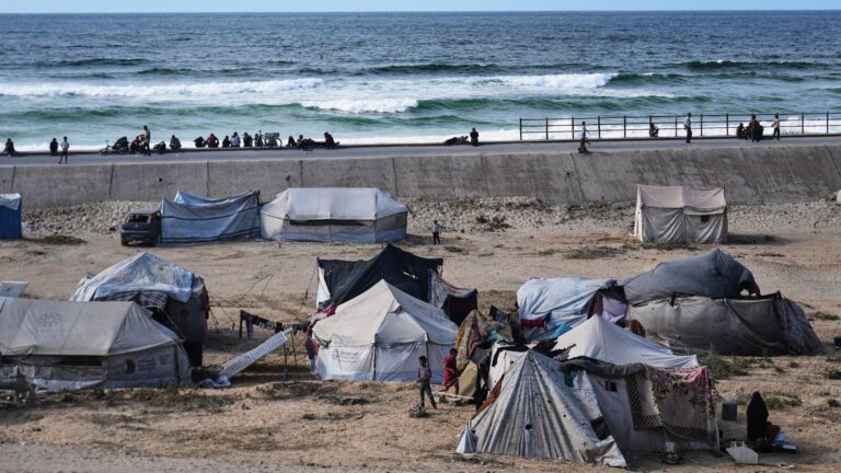 Displaced Palestinians wait on the coastal road near Wadi Gaza in the central Gaza Strip Oct. 9, 2025 during an attempt to return to Gaza City after the announcement that agreed to the first phase of a peace plan to pause the fighting. © AP Photo / Abdel Kareem Hana