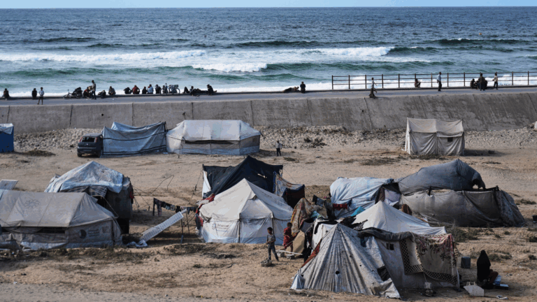 Displaced Palestinians wait on the coastal road near Wadi Gaza in the central Gaza Strip Oct. 9, 2025 during an attempt to return to Gaza City after the announcement that agreed to the first phase of a peace plan to pause the fighting. © AP Photo / Abdel Kareem Hana