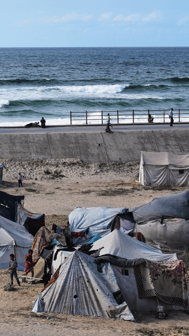 Displaced Palestinians wait on the coastal road near Wadi Gaza in the central Gaza Strip Oct. 9, 2025 during an attempt to return to Gaza City after the announcement that agreed to the first phase of a peace plan to pause the fighting. © AP Photo / Abdel Kareem Hana