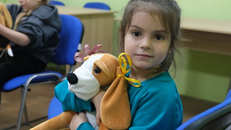 Une petite fille avec Hibuki, un chien en peluche thérapeutique, lors d'une session en santé mentale. Ukraine. © Till Mayer