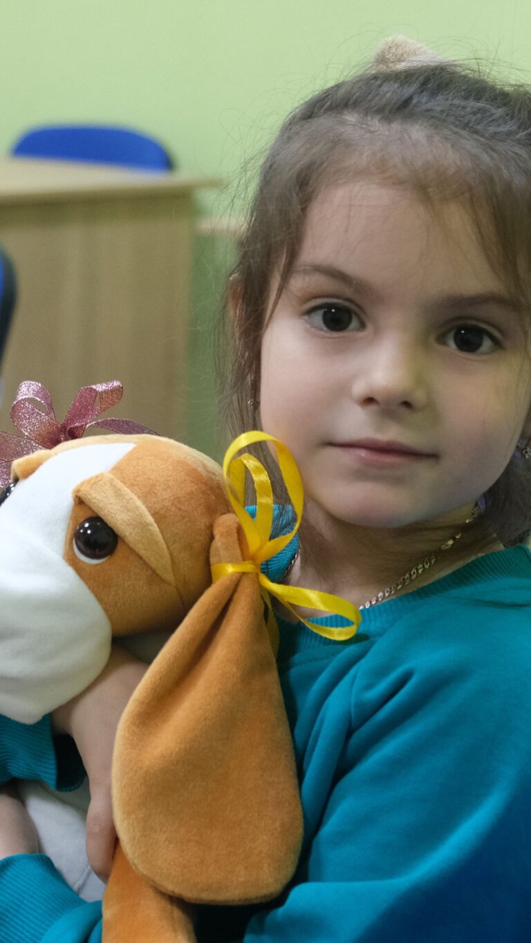 Une petite fille avec Hibuki, un chien en peluche thérapeutique, lors d'une session en santé mentale. Ukraine. © Till Mayer