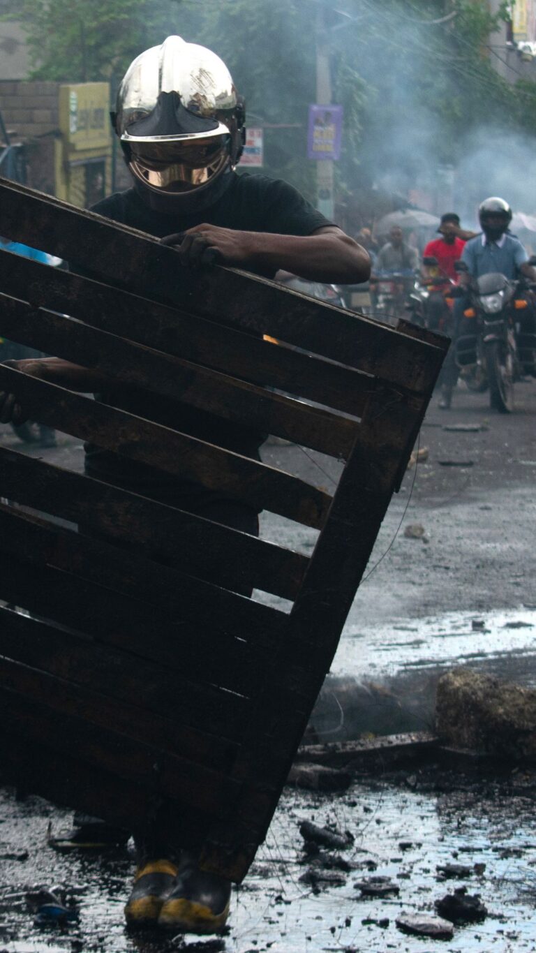 Un membre des pompiers haïtiens enlève une barricade à Port-au-Prince, le 27 octobre 2026 © Keytone / EPA /Jonet St. Elois