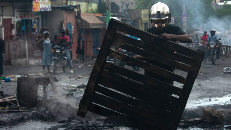 Un membre des pompiers haïtiens enlève une barricade à Port-au-Prince, le 27 octobre 2026 © Keytone / EPA /Jonet St. Elois